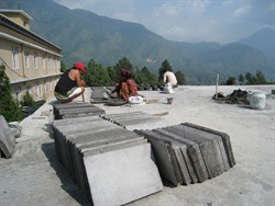 工人利用自製的木板模製造水泥磚