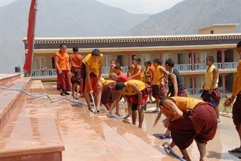 年輕僧侶正在清洗寺院主要入口的石階